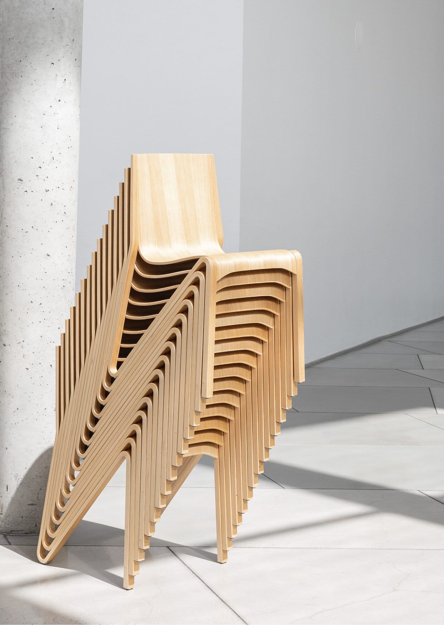 Les chaises Zesty empilées en nombre, coques en bois moulé aux lignes fluides